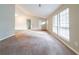 Living area with plush carpeting, vaulted ceiling, abundant natural light, and neutral paint at 5136 Huxley Rd, Stone Mountain, GA 30088