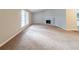 Spacious living room with cozy fireplace, plush carpeting, and large windows for natural light at 5136 Huxley Rd, Stone Mountain, GA 30088
