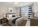 Staged bedroom showcasing a bed, nightstands, and a large window with striped curtains at 2230 Whitestone Pl, Alpharetta, GA 30005