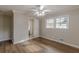 View of a bedroom with ceiling fan, wood-look floors, and a door leading to a bathroom at 4485 Canary Ct, Lithia Springs, GA 30122