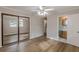 Bedroom with mirrored closet doors, ceiling fan, and wood-look flooring, along with bathroom access at 4485 Canary Ct, Lithia Springs, GA 30122