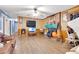 Living room with wood-look flooring, fireplace, ceiling fan, and TV at 654 Noell Nw Way, Lilburn, GA 30047