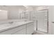 Clean bathroom featuring double sinks, white cabinetry, and a glass shower at 979 Cades Walk, Lawrenceville, GA 30045