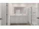 Modern bathroom with double vanity, shower, and white cabinets at 979 Cades Walk, Lawrenceville, GA 30045