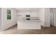 Open-concept kitchen with an island, white cabinetry, and dark wood-look flooring at 979 Cades Walk, Lawrenceville, GA 30045