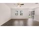 Living room with wood-look floors, white walls, ceiling fan, and door to the outside at 979 Cades Walk, Lawrenceville, GA 30045