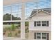 View from a window with blinds overlooking neighboring houses and greenery at 979 Cades Walk, Lawrenceville, GA 30045