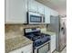 Modern kitchen equipped with stainless steel appliances, white cabinets, and granite countertops at 1624 Graystone Dr, Hampton, GA 30228