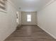 Finished basement area with wood-look flooring, a white brick wall, and natural light at 1852 Shamrock Dr, Decatur, GA 30032