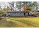 Exterior view of a single-story home with a gray brick exterior and grassy lawn at 1852 Shamrock Dr, Decatur, GA 30032