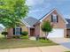 Charming brick home with a landscaped front yard and attached garage at 221 Prominent Loop, Mcdonough, GA 30253