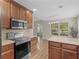 Kitchen with stainless steel appliances, wood cabinets, and island at 221 Prominent Loop, Mcdonough, GA 30253