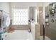 Clean bathroom with a bathtub, shower, and updated fixtures at 9004 Jim Purcell Dr, Covington, GA 30014