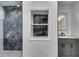 Modern bathroom with gray vanity, marble accent wall, and recessed shelving at 1409 Northgate Dr, Villa Rica, GA 30180