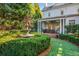 View of the backyard with a fountain, lush landscaping, and a covered porch area with outdoor furniture at 2111 Cooper Lake Se Rd, Smyrna, GA 30080