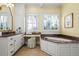 Spacious bathroom with white cabinetry, granite countertops, a soaking tub, and plantation shutters at 2111 Cooper Lake Se Rd, Smyrna, GA 30080