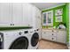 Bright, spacious laundry room with white cabinets, LG washer and dryer, and green accent wall at 2111 Cooper Lake Se Rd, Smyrna, GA 30080