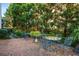 Shady brick patio area with outdoor table and chairs nestled among trees at 2111 Cooper Lake Se Rd, Smyrna, GA 30080