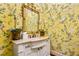 Powder room with yellow floral wallpaper, white vanity, and gold framed mirror at 2111 Cooper Lake Se Rd, Smyrna, GA 30080