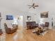 Living room with hardwood floors, a leather sectional sofa, a ceiling fan, and various artwork at 318 Dogwood Trce, Mcdonough, GA 30252