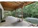 Covered concrete patio area under the deck with outdoor furniture and a wooded view at 4378 Ridge Ct, Loganville, GA 30052
