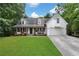 Inviting home with a welcoming front porch, large lawn, and attached two-car garage at 4378 Ridge Ct, Loganville, GA 30052