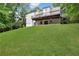 View from the grassy slope of a white two-story house with a large deck at 4378 Ridge Ct, Loganville, GA 30052