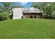 Back exterior of a two story white house with a large deck and green lawn on a slope at 4378 Ridge Ct, Loganville, GA 30052