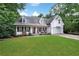 Picturesque home exterior with a covered front porch, surrounded by greenery, and an attached garage at 4378 Ridge Ct, Loganville, GA 30052