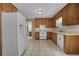 Bright kitchen featuring wood cabinets, white appliances, and tile flooring at 4378 Ridge Ct, Loganville, GA 30052