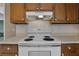 Kitchen features white appliances, wood cabinetry, and tile backsplash at 4378 Ridge Ct, Loganville, GA 30052