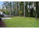 Spacious backyard with lush green lawn, mature trees, and a concrete patio at 1344 Mill Lake Cir, Stone Mountain, GA 30088
