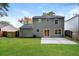 Back exterior view showcasing gray siding, a concrete patio, and grassy backyard at 1344 Mill Lake Cir, Stone Mountain, GA 30088