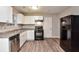 Modern kitchen with white cabinets, dark countertops, stainless steel appliances, and wood-look floors at 1344 Mill Lake Cir, Stone Mountain, GA 30088