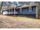 Gray sided ranch home with white trim, red door and a covered porch at 155 Meadowbrook Dr, Mcdonough, GA 30253