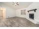 Bright living room featuring a stone fireplace and wood-look flooring at 155 Meadowbrook Dr, Mcdonough, GA 30253