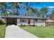 Front view of a ranch home with a red door and driveway at 1933 Glen Echo Dr, Decatur, GA 30032