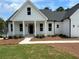 Charming white two-story farmhouse with a covered front porch and landscaped yard at 43 Wickford Way, Villa Rica, GA 30180