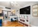 Living room with hardwood floors, open concept kitchen, and large TV at 24 Daniel Se St # 8, Atlanta, GA 30312