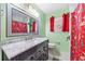 Clean bathroom with a marble countertop vanity and red shower curtain at 1035 Stonewall Se Dr, Atlanta, GA 30315