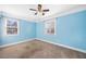 Spacious bedroom with light blue walls, neutral carpet, and two windows at 1035 Stonewall Se Dr, Atlanta, GA 30315