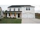 Charming two-story home with white brick exterior, wooden columns, and a two-car garage at 333 Orwell Dr, Social Circle, GA 30025