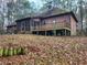 Back of a two-story house with a screened porch and deck at 1447 Upper Sweetwater Se Trl, White, GA 30184