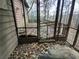 A screened porch with a wooden deck, surrounded by trees at 1447 Upper Sweetwater Se Trl, White, GA 30184