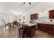 Eat-in kitchen with island, dark wood cabinetry, and stainless steel appliances, open to the dining area at 2635 General Lee Way, Buford, GA 30519