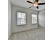 Empty bedroom with two windows, ceiling fan, and carpeted floor at 2689 Richmond Row, Suwanee, GA 30024