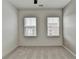 Empty bedroom with two windows and a carpeted floor at 2689 Richmond Row, Suwanee, GA 30024