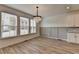 Dining area with wood-look flooring, large windows with blinds, and a stylish chandelier at 2689 Richmond Row, Suwanee, GA 30024