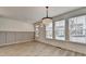 Bright dining room featuring wood-look flooring, modern chandelier, and tasteful wainscoting at 2689 Richmond Row, Suwanee, GA 30024