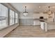 Dining area adjacent to the kitchen with modern chandeliers, wood floors, and large windows at 2689 Richmond Row, Suwanee, GA 30024